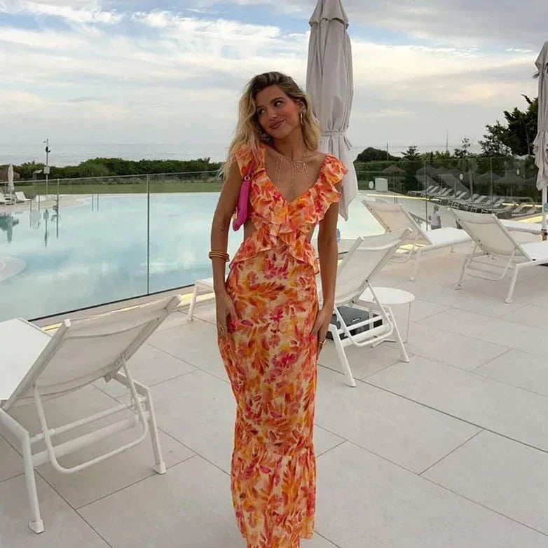 Robe longue à motif floral pour femme, parfaite pour l'été. Avec son décolleté en V et ses volants élégants, cette robe aux couleurs chaudes et vibrantes offre un look moderne et féminin, idéal pour une journée au bord de la piscine ou une sortie décontractée.