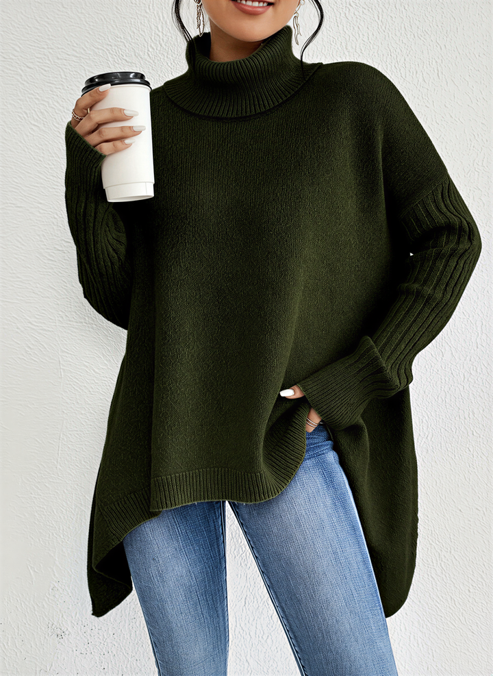 Une femme porte un pull à col roulé vert à la coupe décontractée et élégante. Ce vêtement est doté de longues manches côtelées et d'un ourlet asymétrique, créant une silhouette moderne et décontractée. Associé à un jean slim, l'ensemble évoque un look chic et confortable, idéal pour les journées fraîches. La femme tient une tasse de café à la main, ajoutant une touche urbaine et chaleureuse à la scène.