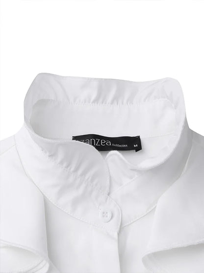 Gros plan sur le col élégant du chemisier blanc, doté d’un bouton discret et d’une finition soignée pour un style raffiné et moderne.