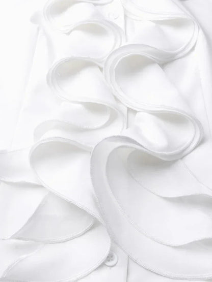 Gros plan sur les volants élégants en tissu blanc fluide, détail raffiné apportant une touche féminine et sophistiquée à ce chemisier chic.