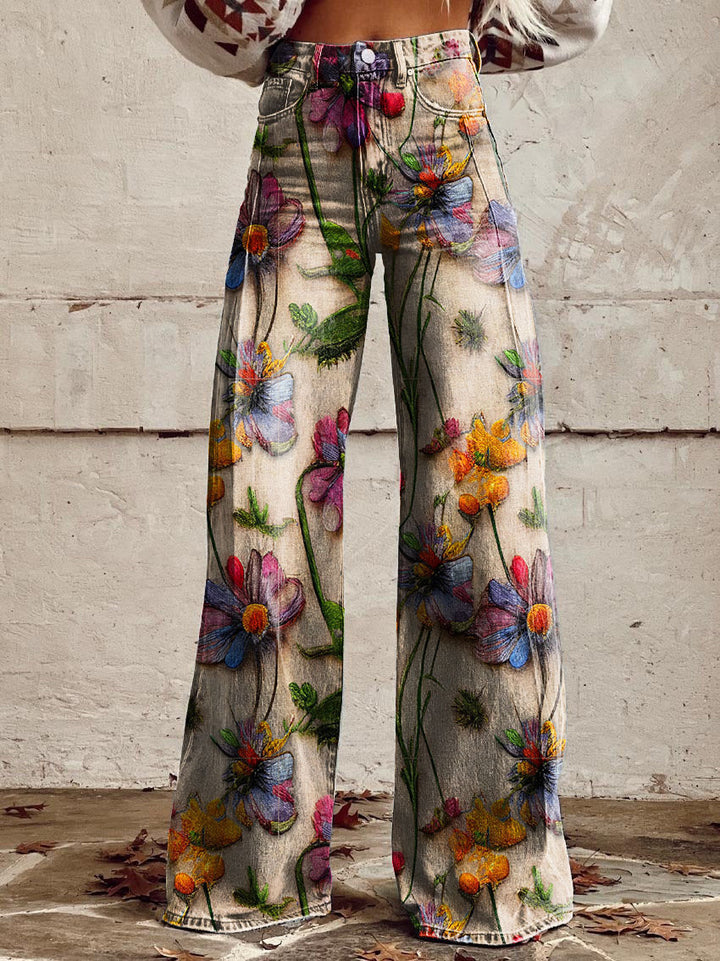 Jeans à taille haute et coupe large pour femmes, imprimés de fleurs, avec un mélange de fleurs et de feuilles vibrantes sur un fond beige, idéals pour des looks décontractés et sportifs.