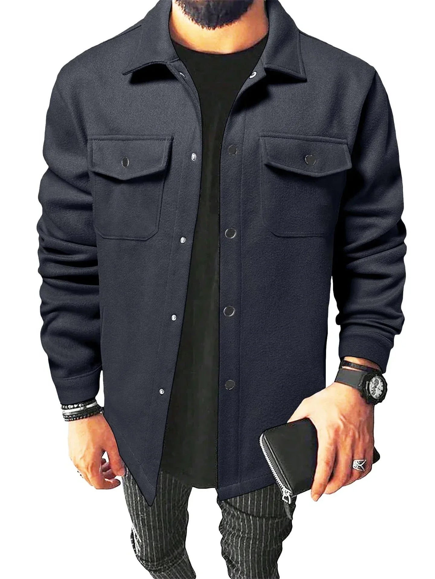 Jules | Chemise oversize pour homme, à manches longues, de couleur bleue foncée avec poches poitrine et boutons métalliques, portée avec un t-shirt noir et un pantalon à rayures.