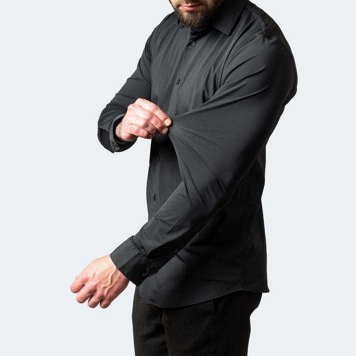 Chemise stretch à manches longues pour homme, modèle Julien, de couleur noire, coupe ajustée, tissu extensible démontré au niveau de la manche pour un confort optimal et une grande liberté de mouvement, idéale pour un look moderne et élégant.