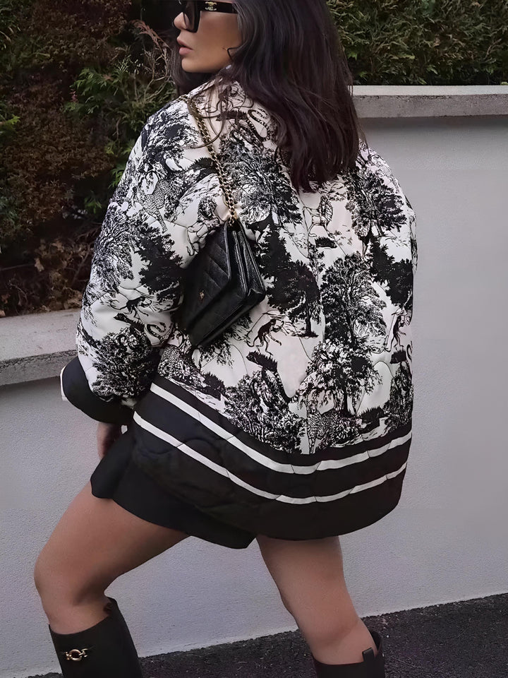 Veste courte d’hiver pour femme Kérina avec motif noir et blanc artistique, vue de dos. Modèle élégant et tendance, portée avec une jupe noire, des bottes hautes et un sac à chaîne, idéale pour un look hivernal chic et moderne.