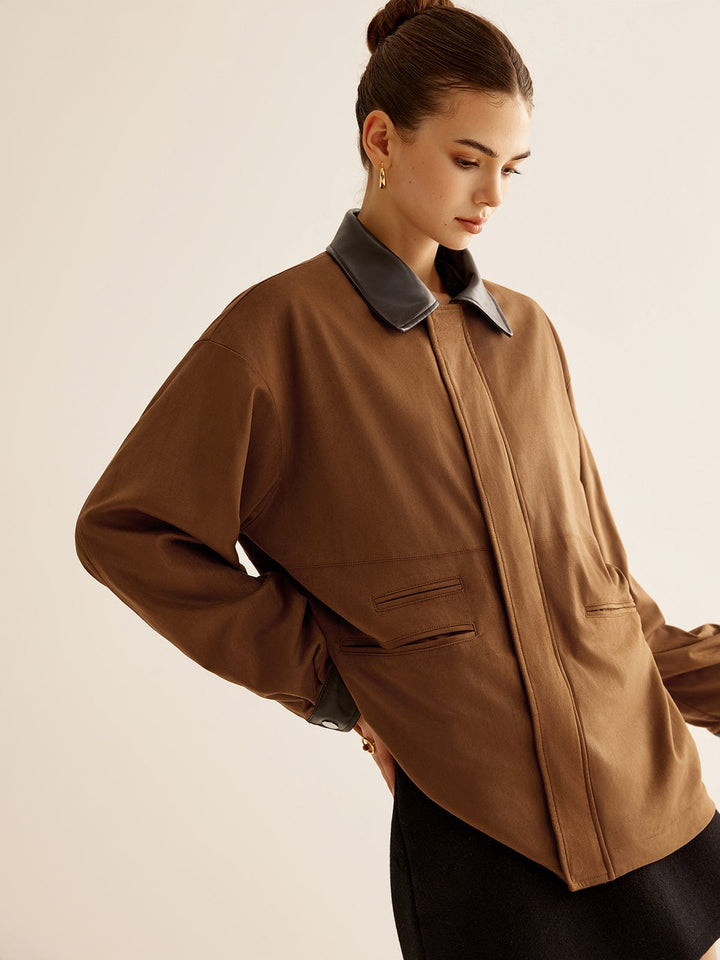 Veste oversize Kylora pour femme, vue de profil mettant en avant le col en cuir noir et la coupe décontractée. Ce modèle tendance allie confort et style, parfait pour une allure moderne et élégante, avec des poches latérales discrètes.