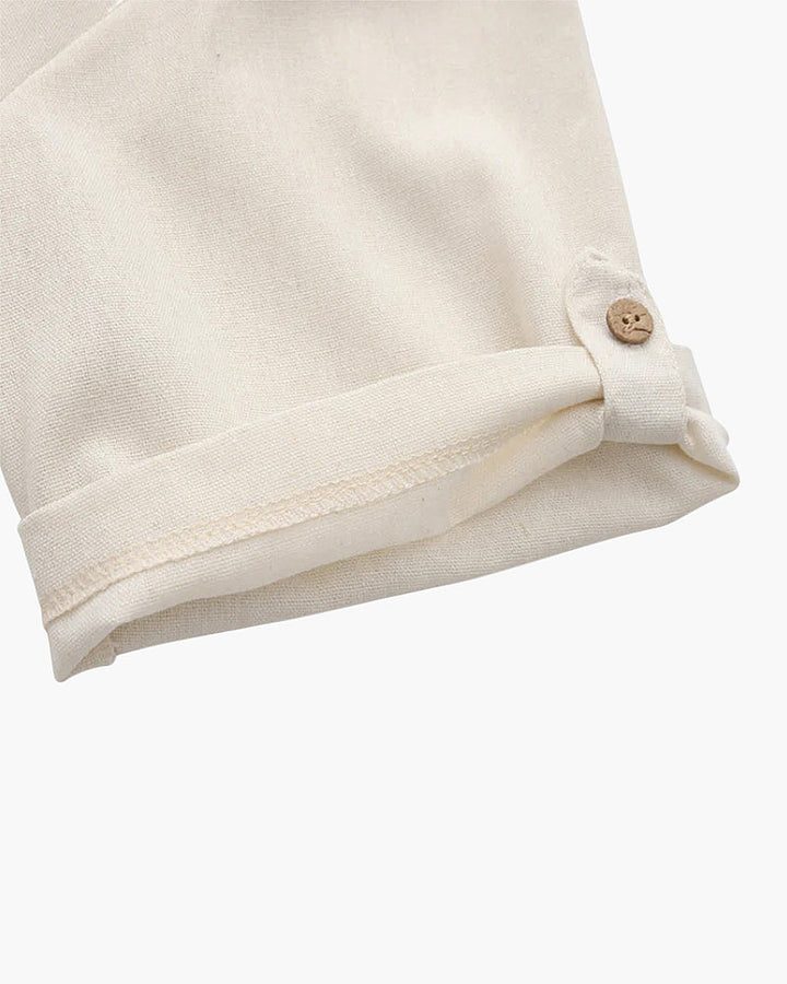 Zoom sur le bas de la manche du polo en lin pour homme, couleur beige clair, avec un bouton en bois qui permet de replier les manches pour un look soigné et tendance. Un détail élégant pour un style décontracté et raffiné.