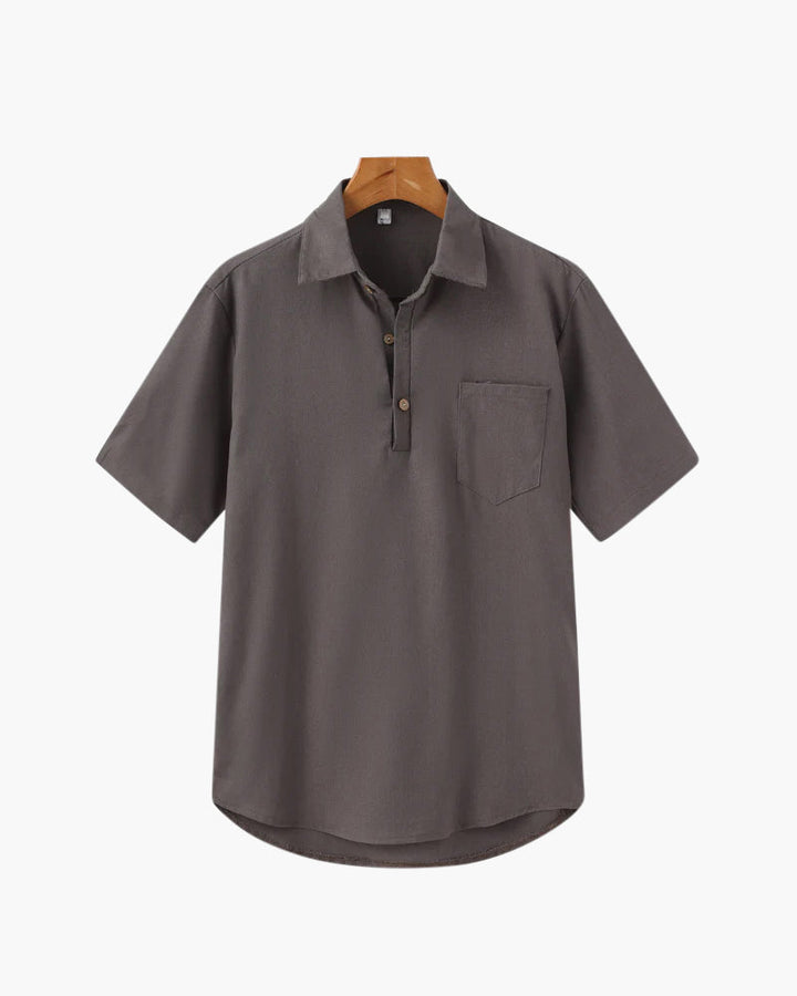 Polo en lin pour homme, couleur gris foncé, avec une poche poitrine et des boutons au col. Ce modèle épuré et élégant est parfait pour un look décontracté et moderne, idéal pour les journées chaudes.