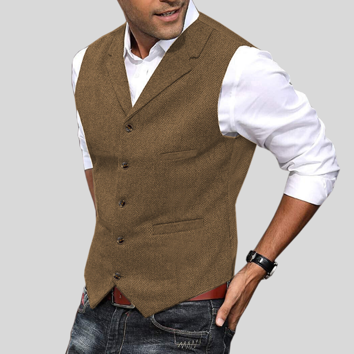 Gilet court sans manches marron à boutons, coupe ajustée avec poches, porté sur une chemise blanche avec jean.