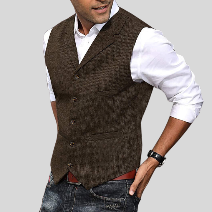 Gilet court sans manches marron foncé à boutons, coupe ajustée avec poches, porté sur une chemise blanche avec jean.
