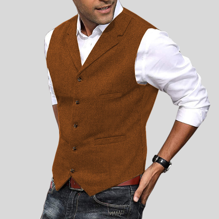 Gilet court sans manches marron caramel à boutons, coupe ajustée avec poches, porté sur une chemise blanche avec jean.