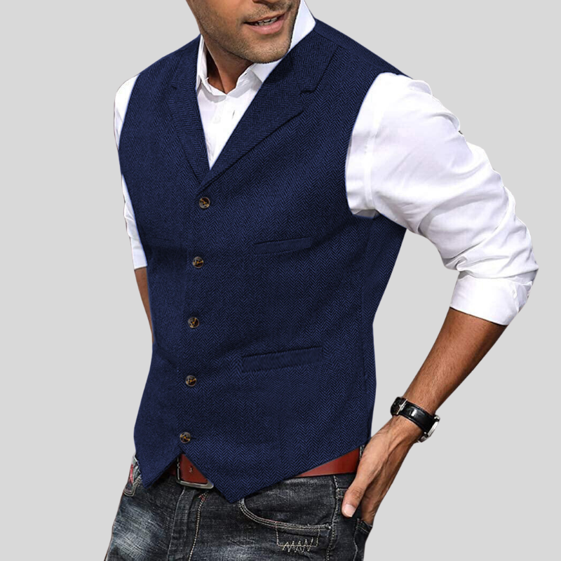 Gilet court sans manches bleu marine à boutons, coupe ajustée avec poches, porté sur une chemise blanche avec jean.