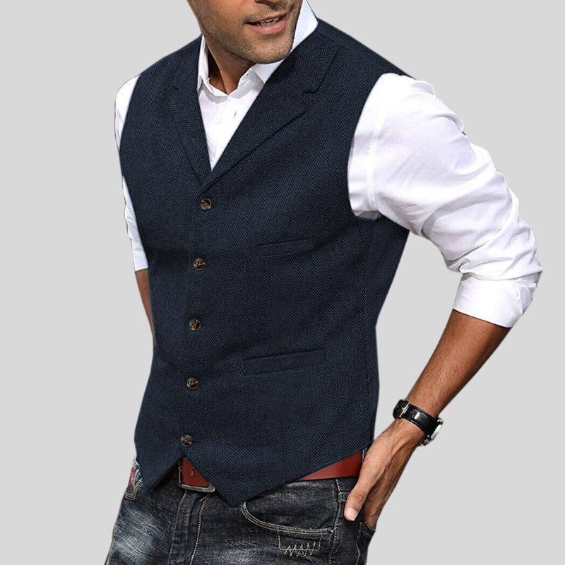 Gilet court sans manches bleu marine chiné à boutons, coupe ajustée avec poches, porté sur une chemise blanche avec jean.