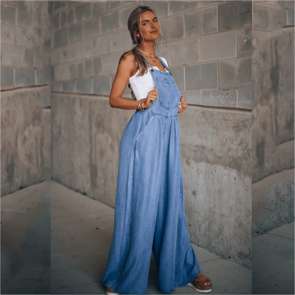 Combinaison en denim Lane pour femme, moderne et élégante, avec bretelles et coupe ample à jambes larges. Style décontracté chic, portée avec un top blanc, idéale pour un look tendance et confortable au quotidien.