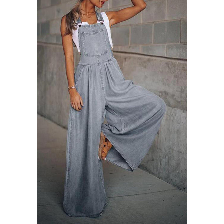 Combinaison en denim Lane pour femme, version gris clair, avec bretelles et coupe ample à jambes larges. Style moderne et fluide, portée avec un top blanc, idéale pour un look casual chic et tendance au quotidien.
