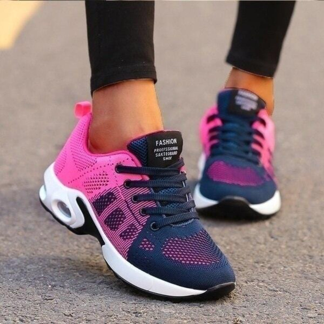 Baskets basses pour femme aux couleurs rose et bleu marine avec semelle blanche épaisse, portées avec un legging noir, présentant un design moderne, respirant et confortable, idéales pour la marche et un usage quotidien.
