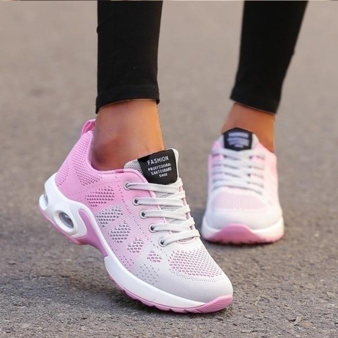Baskets basses pour femme aux tons rose et blanc avec semelle épaisse, portées avec un legging noir, affichant un design moderne, léger et respirant, idéales pour la marche et le quotidien.