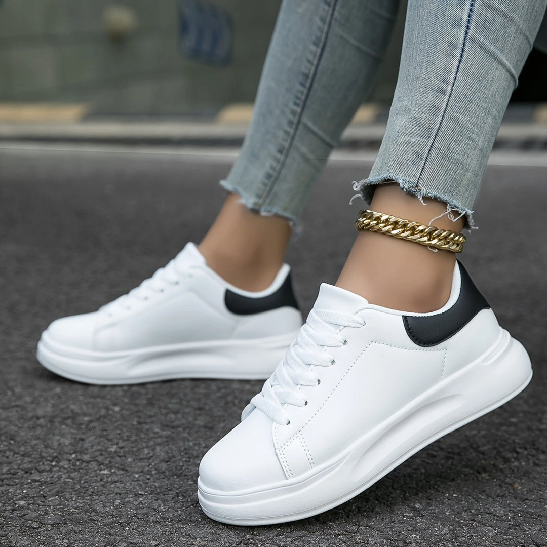 Sneakers orthopédiques pour femme Layssa, blanches avec des détails noirs au talon, offrant confort et soutien, parfaites pour un style décontracté et tendance.