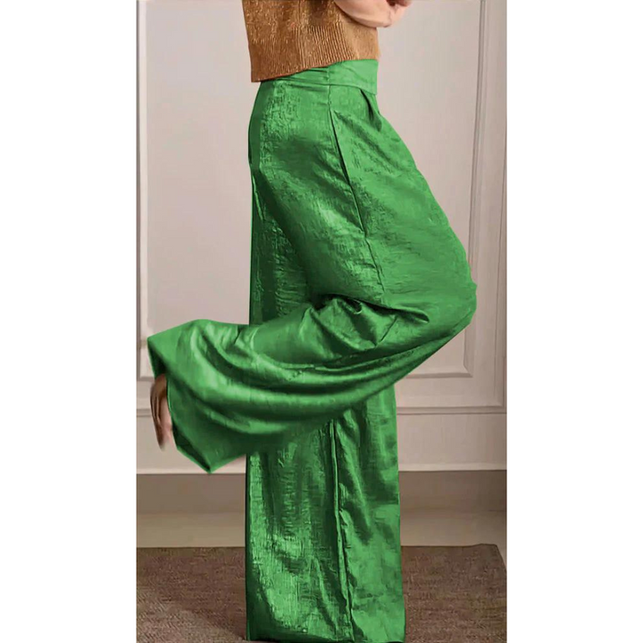 Un ensemble moderne pour femme avec un haut en maille dorée et un pantalon fluide vert vif, à la coupe large et au tissu brillant, créant un look audacieux et élégant.