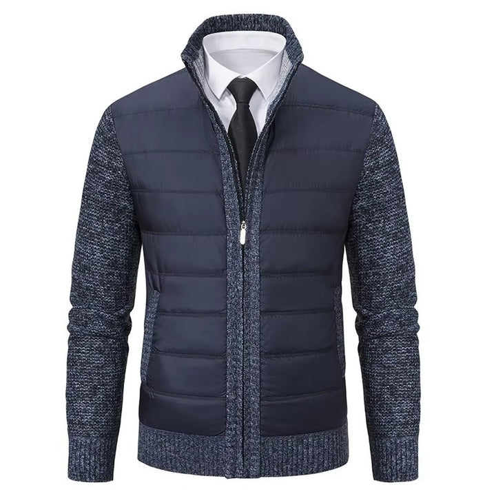 Veste moderne pour homme, avec un gilet matelassé bleu marine sur le devant et un tricot bleu marine texturé sur les manches et les côtés. Elle présente une fermeture éclair centrale, un col élégant et une coupe ajustée, idéale pour une tenue élégante et décontractée en hiver.