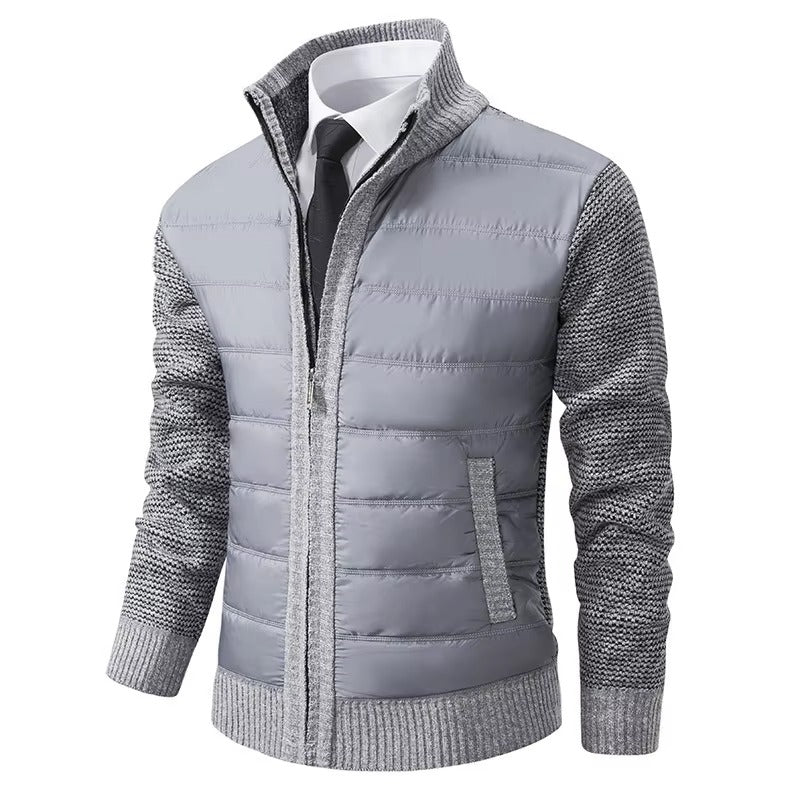 Veste moderne pour homme, avec un gilet matelassé gris clair sur le devant et un tricot gris texturé sur les manches et les côtés. Elle présente une fermeture éclair centrale, un col élégant et une coupe ajustée, idéale pour un look élégant et confortable lors des journées plus fraîches.