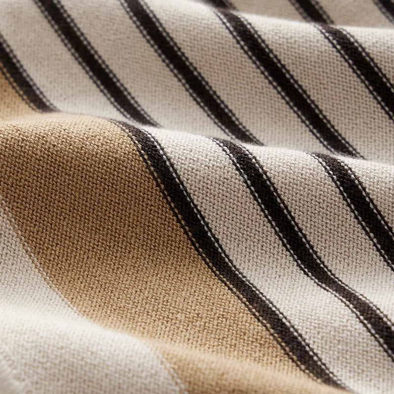 Zoom sur le tissu du polo homme Leroy, avec des rayures horizontales beiges et noires. Le tissu texturé et élégant reflète un style moderne et raffiné, parfait pour une tenue à la fois décontractée et tendance.