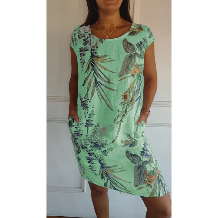 Cette robe d'été légère en lin, avec un imprimé tropical vibrant, offre une coupe décontractée et confortable. Elle présente des poches latérales pratiques et un design frais et coloré, parfait pour les journées chaudes. Idéale pour un look estival élégant et pratique.