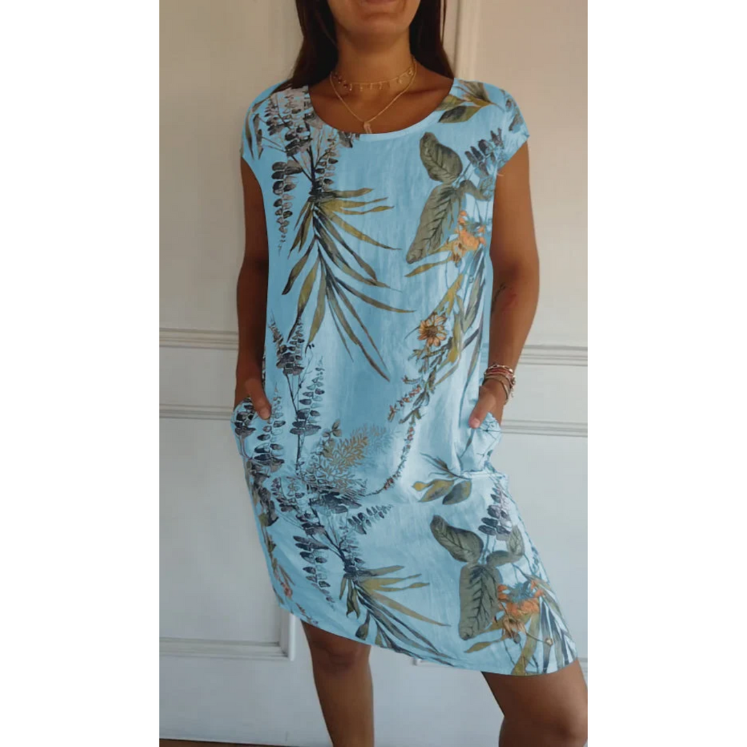 Cette robe d'été légère en lin, de couleur bleu clair avec un imprimé floral tropical, est parfaite pour un look estival frais et décontracté. Elle offre une coupe confortable avec des poches latérales pratiques, idéale pour les journées ensoleillées.