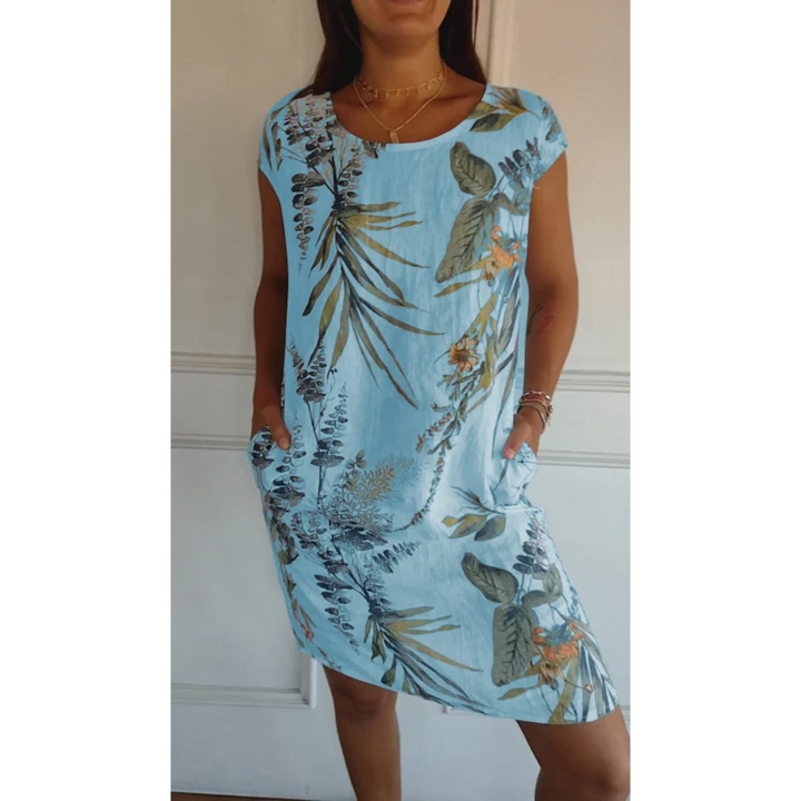Cette robe d'été légère en lin, de couleur bleu clair avec un imprimé floral tropical, est parfaite pour un look estival frais et décontracté. Elle offre une coupe confortable avec des poches latérales pratiques, idéale pour les journées ensoleillées.