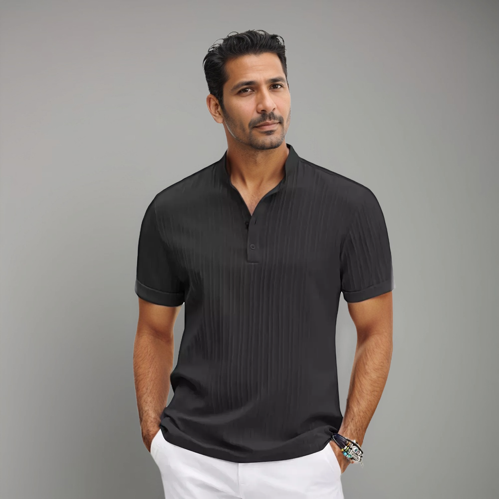 Homme portant un polo noir à manches courtes avec un col à boutons et un motif rayé discret, combiné à un style moderne et élégant. Un choix parfait pour un look à la fois décontracté et raffiné.
