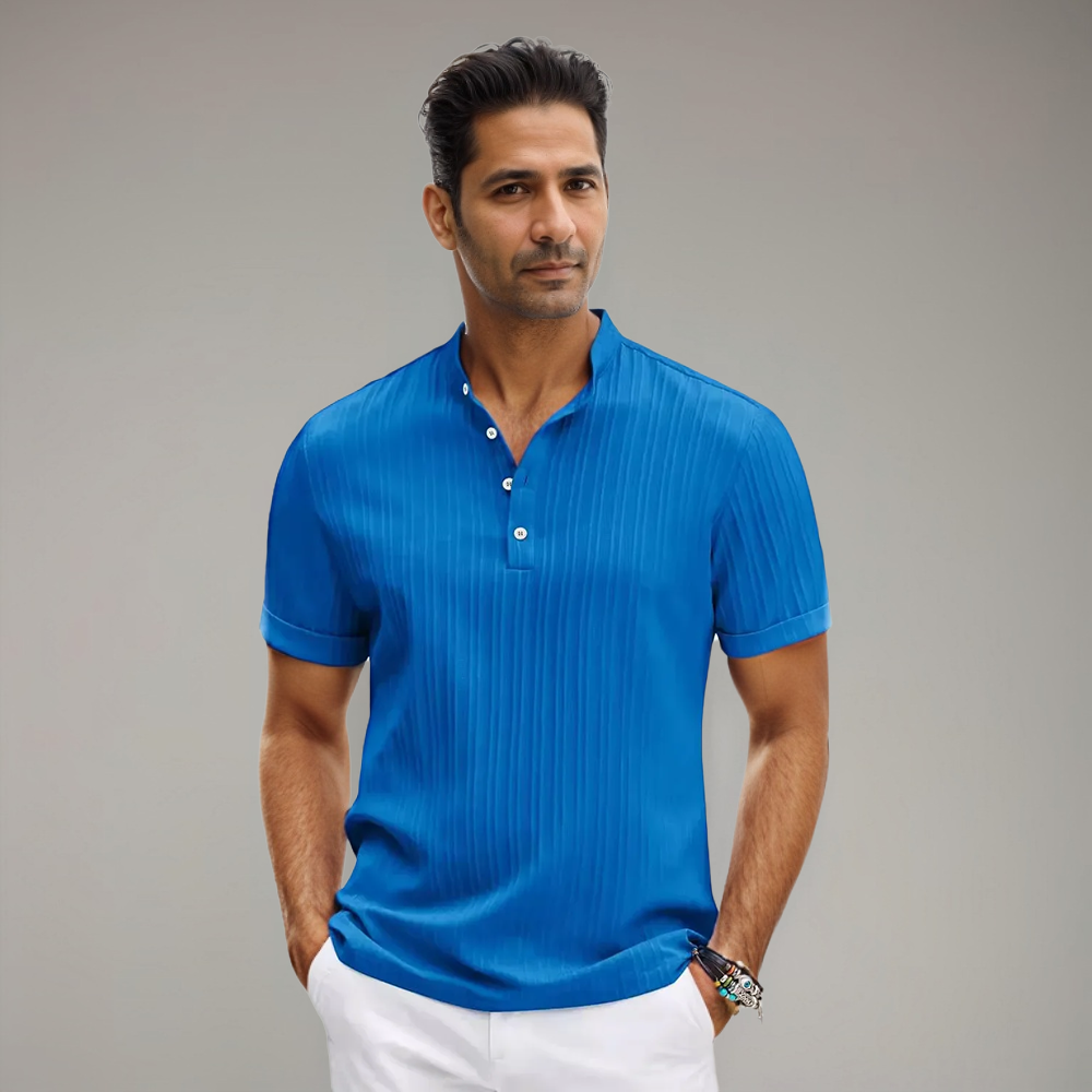 Homme portant un polo bleu vif à manches courtes, avec un col à boutons et un motif rayé subtil. Un choix parfait pour un look estival dynamique, moderne et élégant.