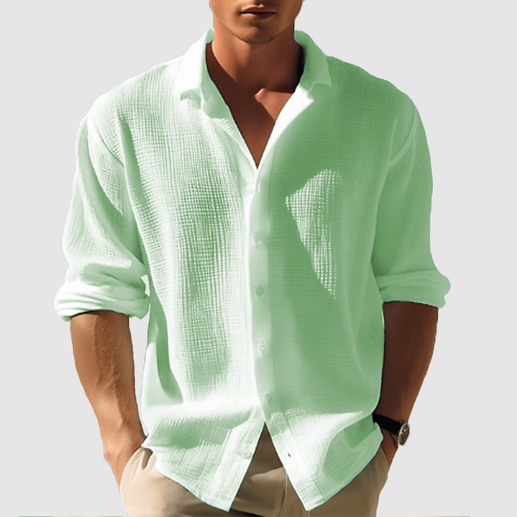 Homme portant la chemise Lothaire moderne à manches longues, en tissu texturé vert menthe, col ouvert et coupe décontractée, idéale pour un style frais et élégant.