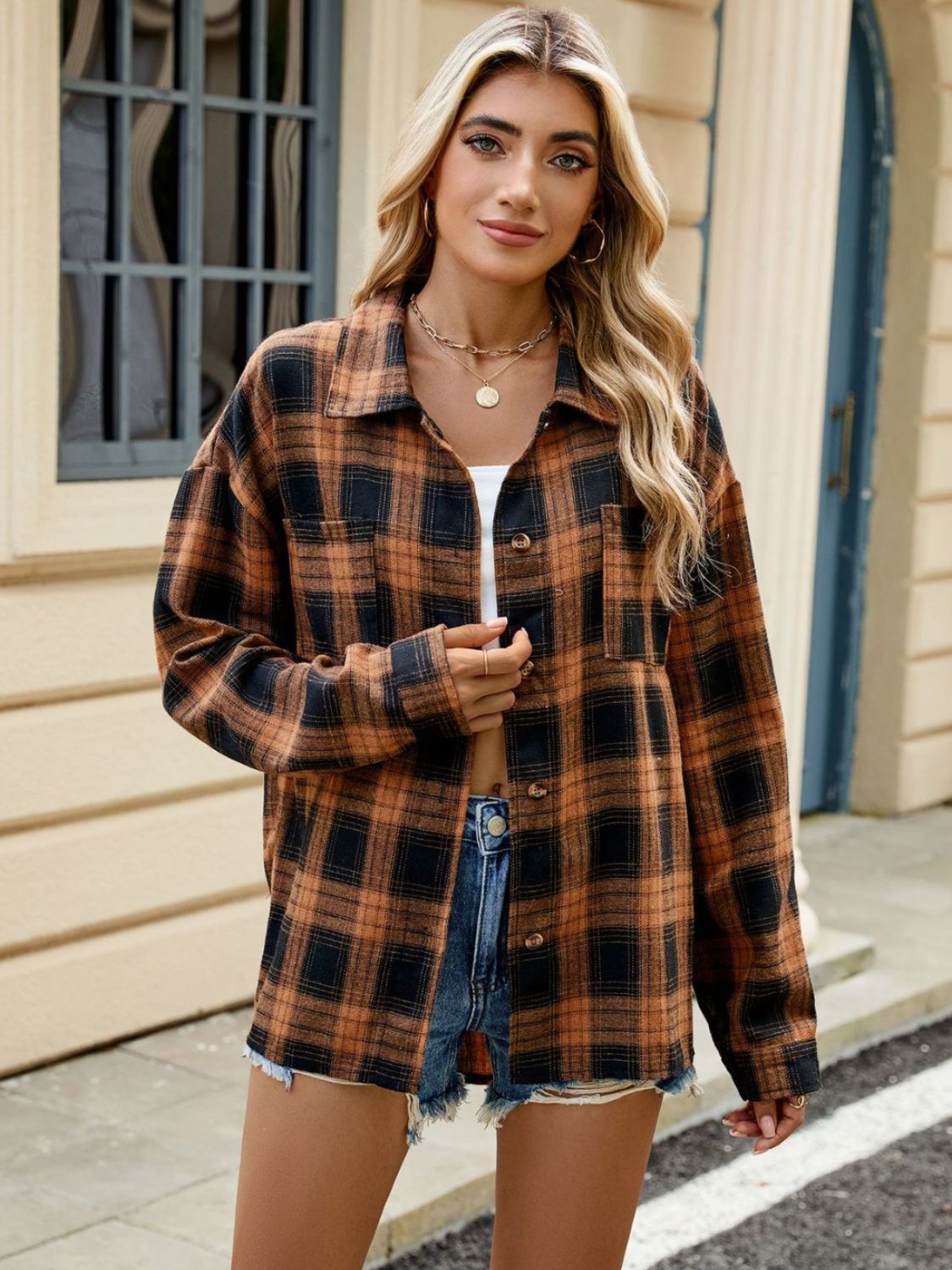 Chemise à carreaux orange et noir, coupe ample avec boutons, idéale pour un look casual et confortable.