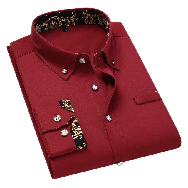 Chemise longue pour hommes Ludovic moderne bordeaux, pliée avec col boutonné et détails baroques dorés à l’intérieur du col et sur les poignets, présentée sur fond clair.