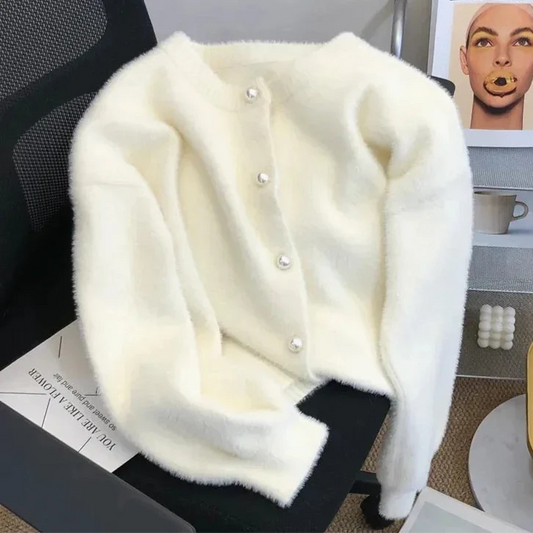 Cardigan chic pour femme Luna, orné de boutons en perles élégants, posé sur un bureau moderne avec un décor minimaliste, parfait pour une touche de raffinement décontracté.