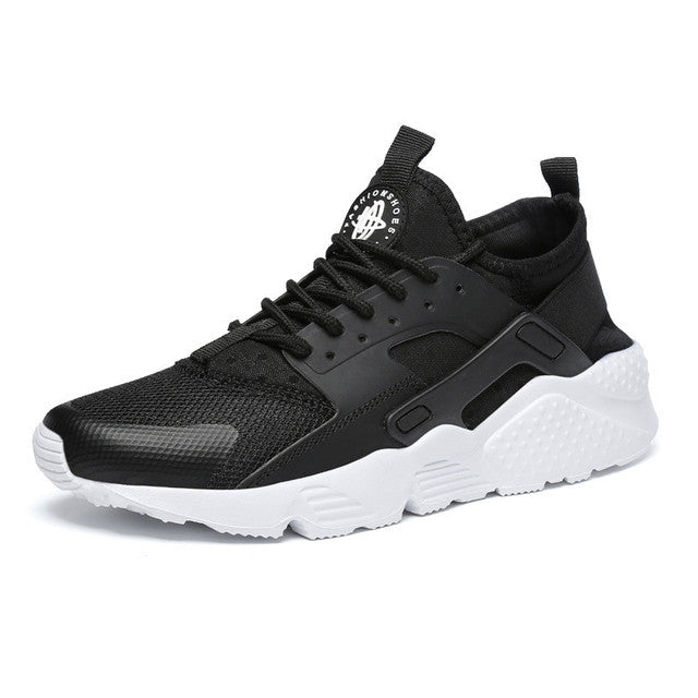 Sneaker homme noire en mesh respirant, avec lacets et empiècements, semelle épaisse blanche amortissante, look urbain.