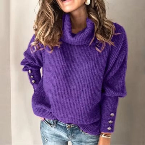 Femme portant un pull à col roulé ample de couleur violette avec des boutons argentés décoratifs sur les manches. Le tissu est doux et épais, offrant un style élégant et confortable, parfait pour un look tendance et chaleureux pendant la saison froide.