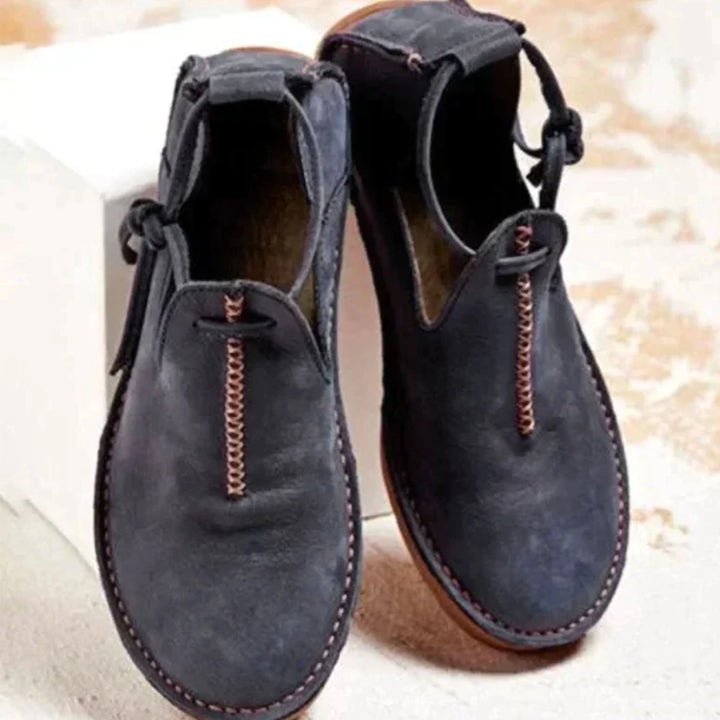 Chaussures confortables pour femme en cuir noir, avec une finition soignée et une fermeture à lacet décorative. Un modèle à la fois tendance et pratique, idéal pour un look décontracté et élégant au quotidien.