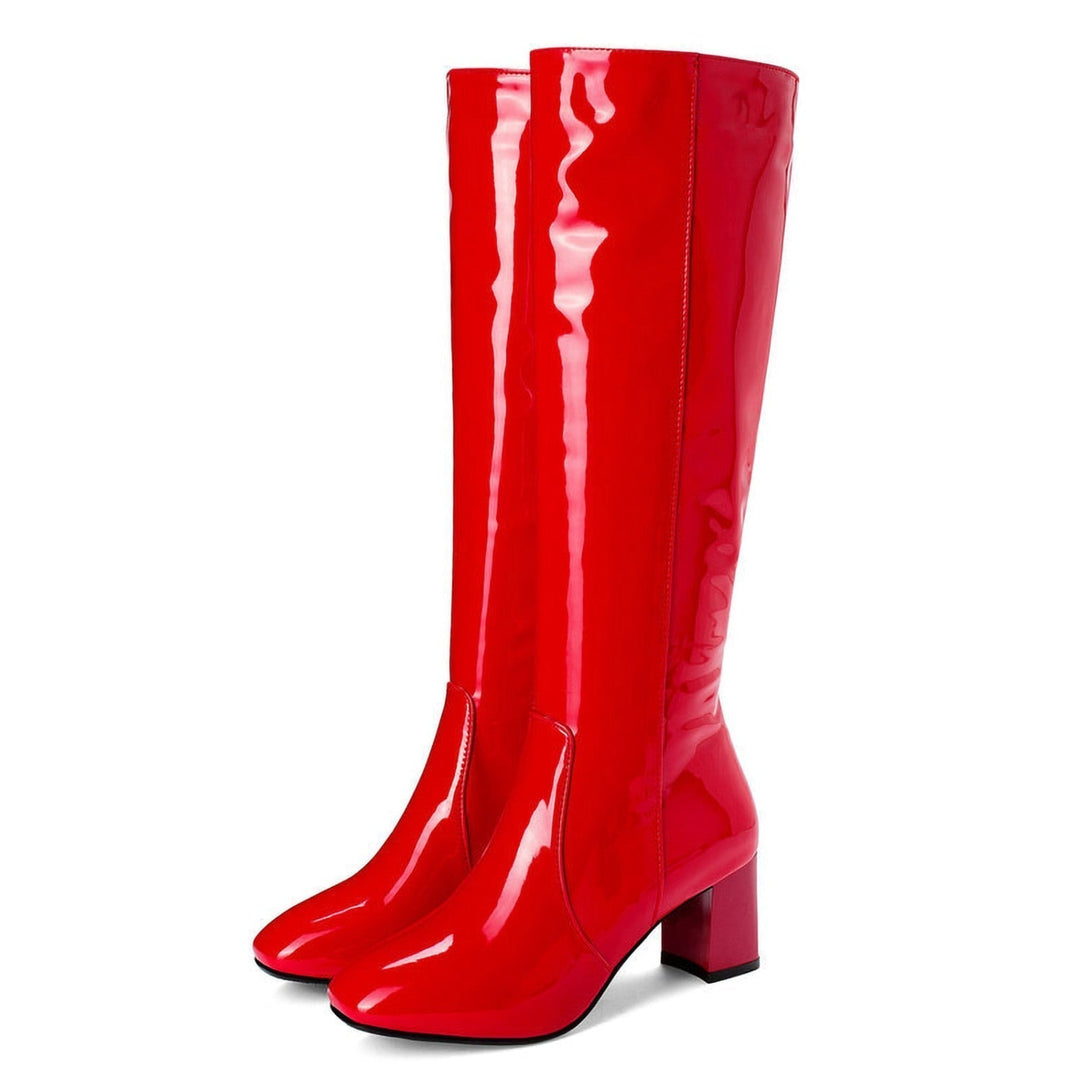 Une paire de bottes rouges brillantes montantes jusqu'aux genoux avec un bout carré et des talons épais. Ces bottes en cuir verni, au design tendance, sont conçues pour les femmes, offrant à la fois une mode audacieuse et du confort. Les bottes possèdent une finition lisse et brillante, parfaites pour faire une déclaration de style.
