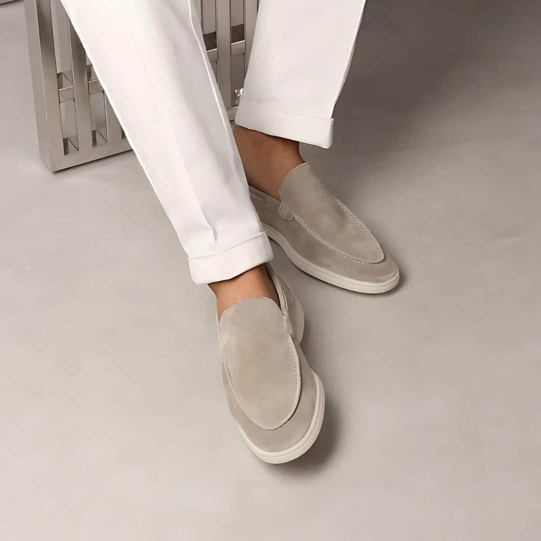 Mocassins en daim beige portés avec un pantalon blanc, offrant un look moderne et élégant, idéal pour un style décontracté et raffiné.