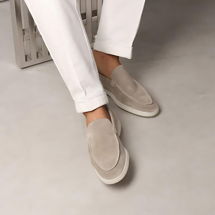 Mocassins en daim beige portés avec un pantalon blanc, offrant un look moderne et élégant, idéal pour un style décontracté et raffiné.