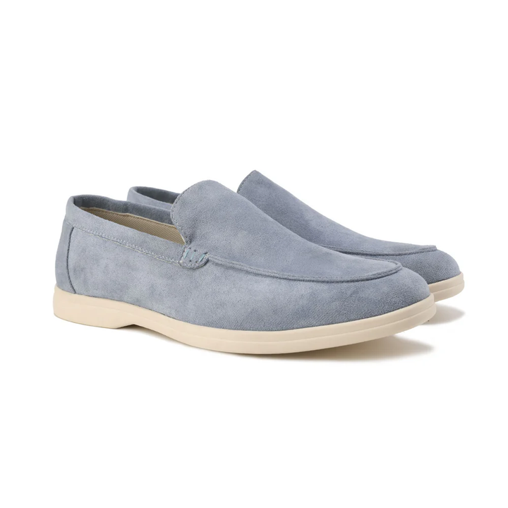 Mocassins en daim bleu clair avec une finition soignée et une semelle beige, idéals pour un look moderne et élégant.