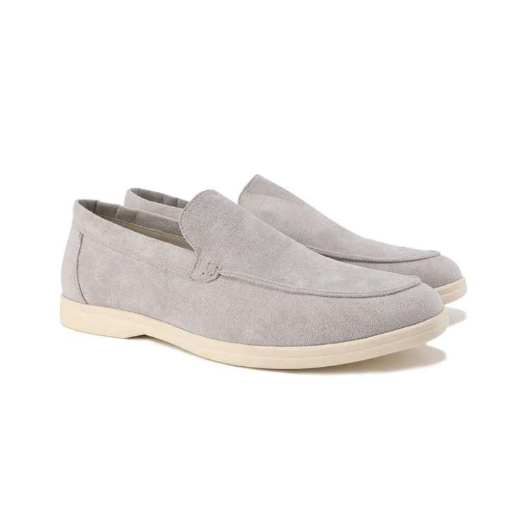Mocassins en daim gris clair avec une finition élégante et une semelle beige, offrant confort et style pour une allure moderne et sophistiquée.