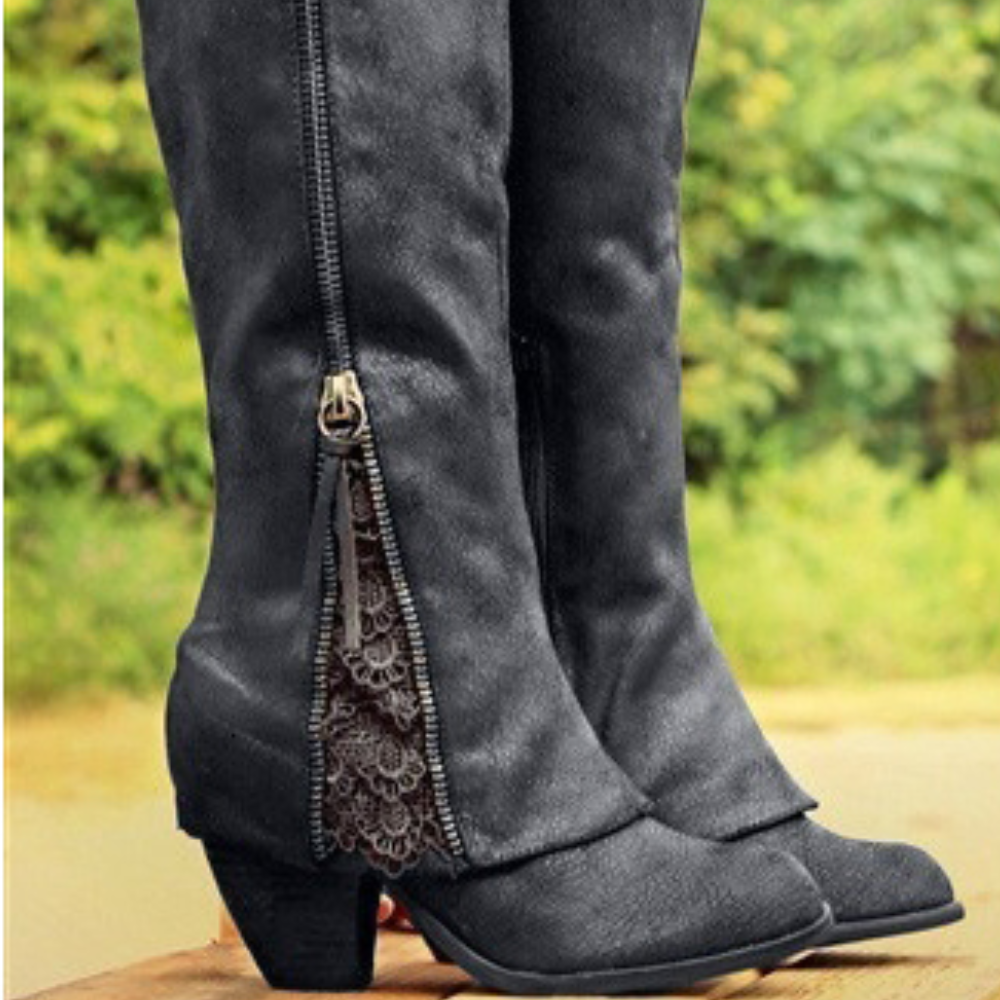 Bottes noires en cuir pour femme, avec une coupe haute et une fermeture éclair sur le côté ornée de dentelle. Elles sont dotées d'un petit talon carré, parfaites pour ajouter du style à vos tenues tout en offrant confort et élégance.