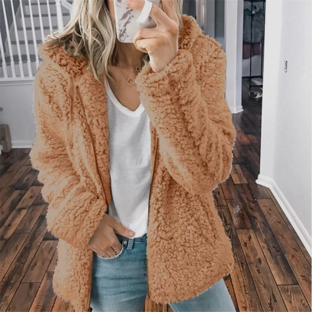 Femme portant la veste d’hiver courte Marie en fausse fourrure chaude, couleur camel, associée à un t-shirt blanc et un jean, pour un look moderne et confortable.
