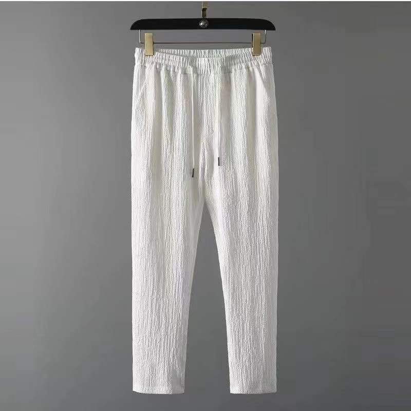 Avec taille élastique et cordon de serrage, confectionné dans un tissu léger et texturé pour un confort optimal et un style moderne et épuré.