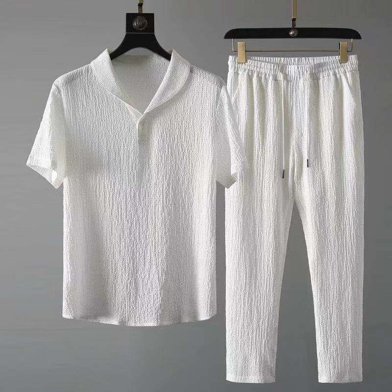 Ensemble d’été pour homme moderne en blanc, comprenant une chemise à manches courtes avec col ouvert et un pantalon assorti à taille élastique, réalisé dans un tissu léger et texturé pour un look élégant, frais et confortable.