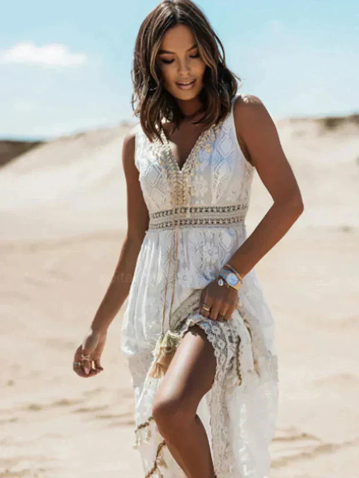 Robe légère et élégante, en dentelle blanche avec des détails bohèmes, parfaite pour un look estival chic et raffiné.