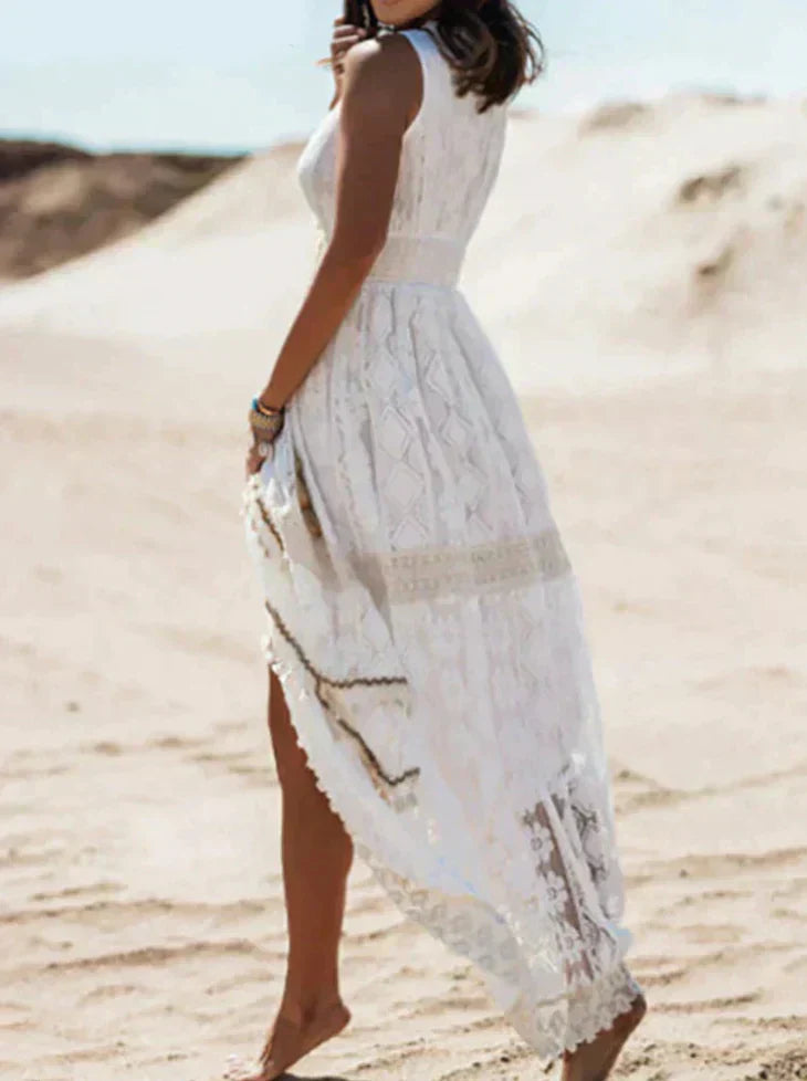 Robe longue en dentelle blanche avec une fente latérale, offrant un style élégant et bohème, idéale pour les journées d'été.