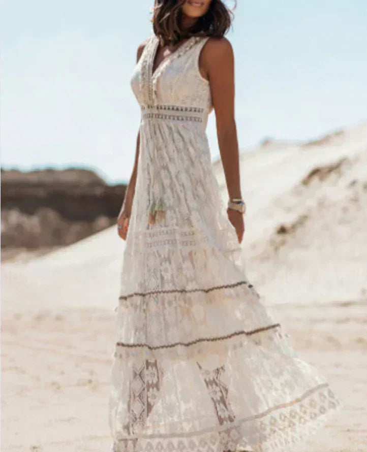 Robe longue et fluide en dentelle blanche, à coupe bohème, parfaite pour un look estival élégant et léger.