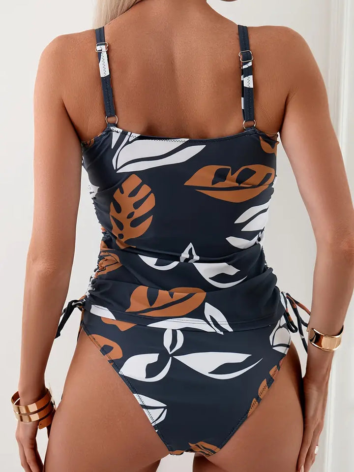Vue arrière du tankini avec ses bretelles ajustables et ses fronces élégantes, mettant en avant les motifs tropicaux et la coupe flatteuse du bas assorti.